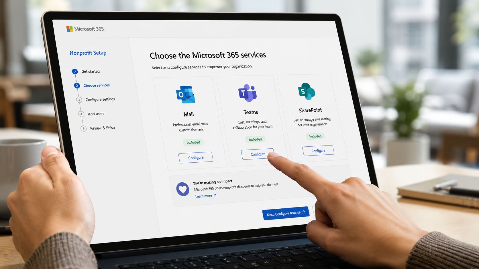 Eine Hand bedient einen Laptop, auf dem die Microsoft 365 Konfiguration für gemeinnützige Organisationen angezeigt wird.